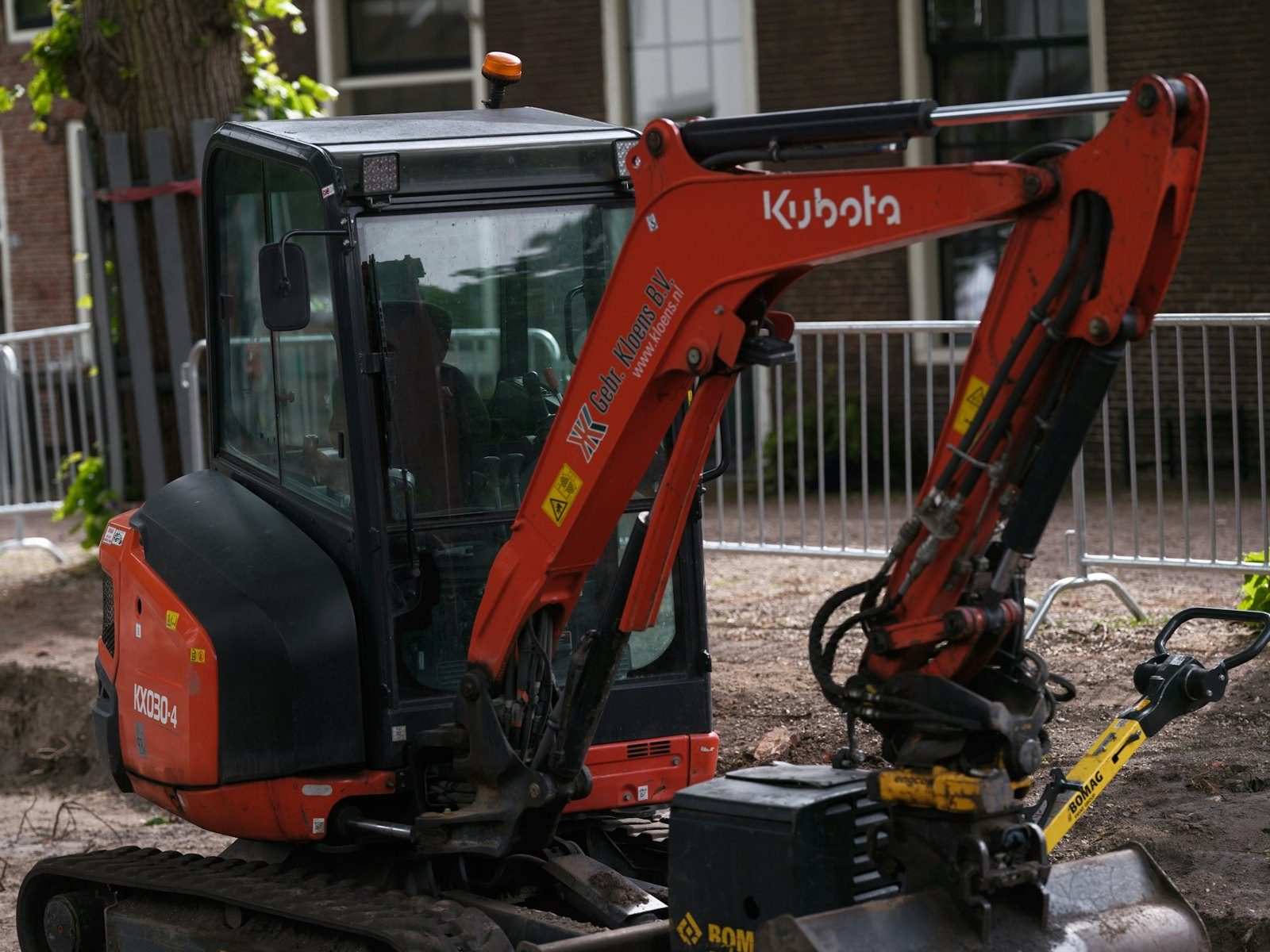 Kubota mini digger with a tilt bucket on a site in town